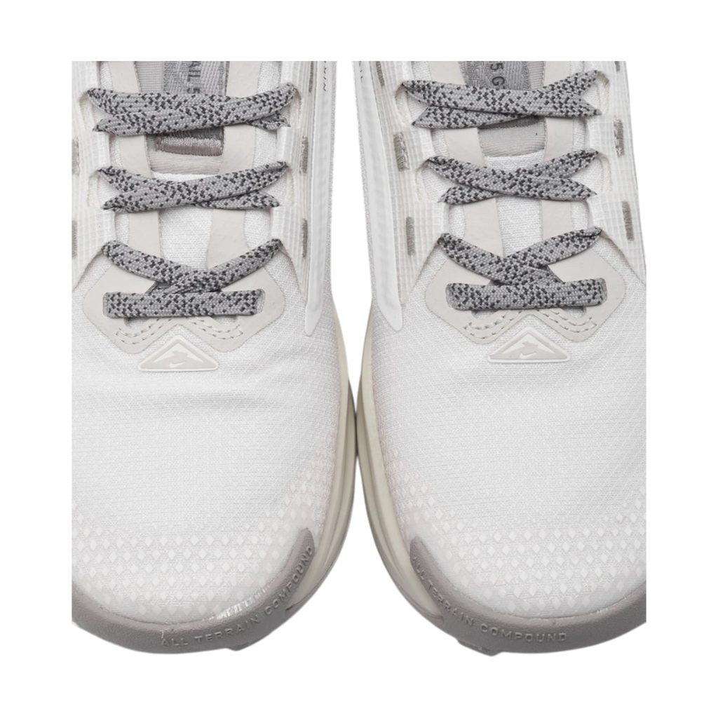 Detalle frontal de zapatillas THE KICKS WORLD Nike React Pegasus Trail 5 GORE-TEX blancas y grises con cordones moteados